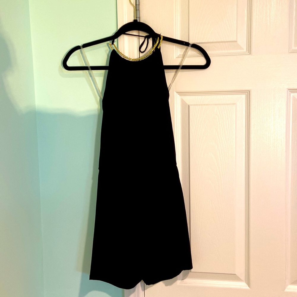 A medium black romper with gold at the chest